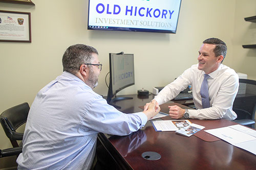 Financial advisor Christian helping a client. The two have finished up and are shaking hands.